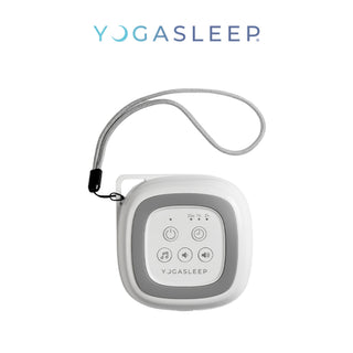 A Yogasleep Travelcube Portable Sound Machine with a gray and white design is shown. The device features buttons for power, volume control, and sound selection. It’s a travel essential with an attached lanyard for easy carrying, and the Yogasleep logo is displayed above it.