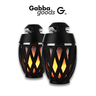 Two black, oval-shaped Gabba Goods Bluetooth LED Flame Speakers with a lattice design and soft orange glowing lights inside. The brand name "Gabba Goods" and logo are displayed above the speakers, which feature True Wireless Stereo (TWS) connectivity for an immersive audio experience.