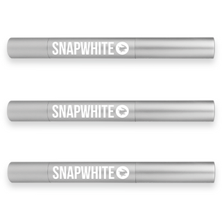 Three cylindrical silver pens labeled "Snapwhite" are aligned horizontally, promising effective teeth whitening. The text and logo, a circular emblem with a stylized tooth, are displayed in white. These Advanced Teeth Whitening Travel Pens (3-Pack) feature a sensitivity-friendly gel formula and are evenly spaced against a plain white background.